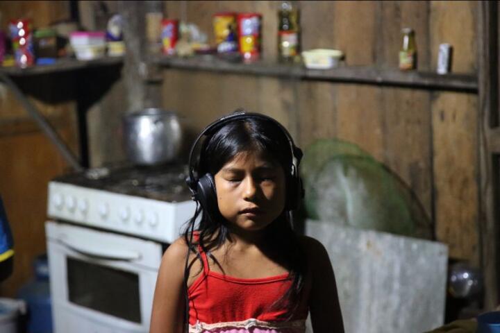 young girl listens on headphones