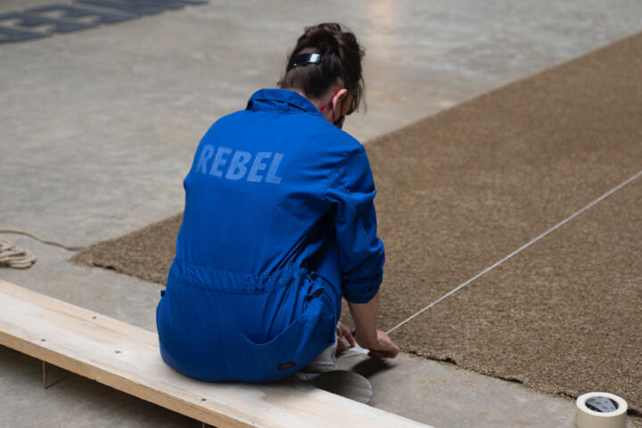 figure in a worksuit with Rebel stencilled on the back