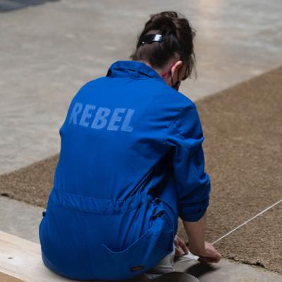 figure in a worksuit with Rebel stencilled on the back