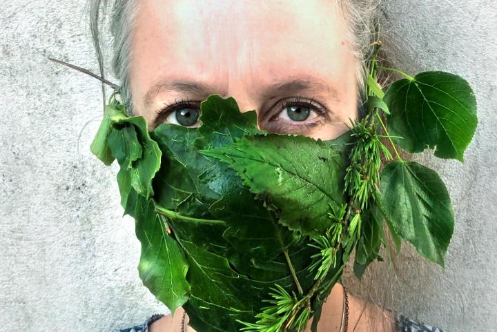 woman in face mask made of leaves