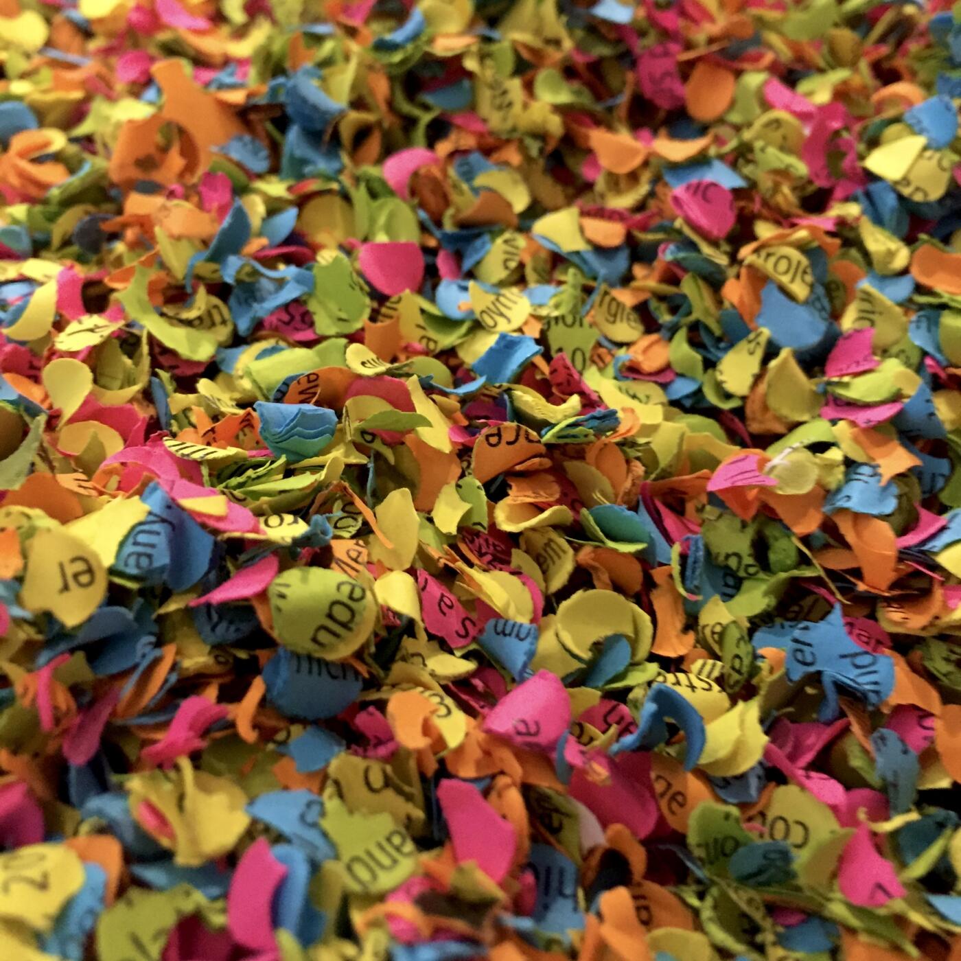 Brightly coloured shreds of paper with printed text fill the screan: the IPCC report has been turned into confetti.