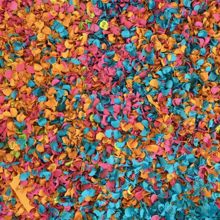 A large pile of brightly coloured shreds of paper with printed text fill the screan: the IPCC report has been turned into confetti.